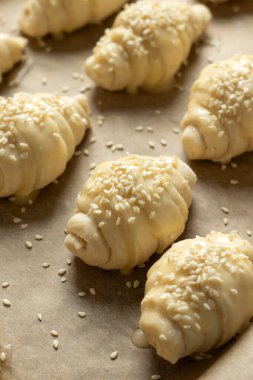 Ev yapımı hilal hamur ve susam tohumlarını tavaya koyar. Üst görünüm.