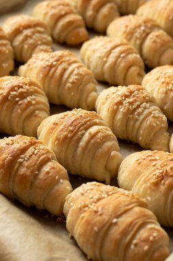 Tavada susam tohumlu fırınlanmış hilal ruloları. Taze ev yapımı hamur işi.