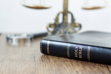 Arkasında antika denge ölçeği ve büyüteç olan kutsal İncil kitabı. Yakın plan. Tanrı 'nın kanunu, adaleti ve adil yargılama Hristiyan konsepti.