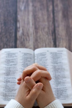 Ellerin açık kutsal kitap üzerinde dua ediyor. Uzayı kopyala Hristiyan minnettarlığı, övgüler ve Tanrı 'ya dua. İncilsel kavram.
