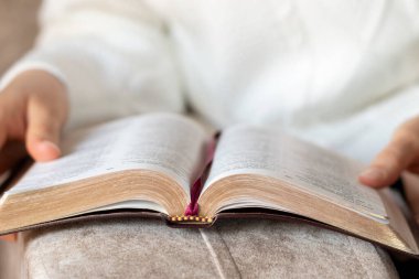 Kadın kutsal kitaptan bir şeyler okuyor. Yakın plan. Seçici odaklanma. Hıristiyan Kutsal Kitap kavramı öğrenimi.