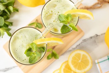 Nane şekerli limonata ve beyaz mermer mutfak masası. Üst Manzara. Sağlıklı ev yapımı soğuk yaz kokteyli..