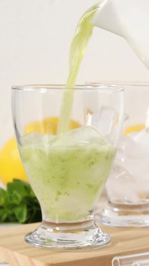 Bardağa ferahlatıcı limonlu meyve püresi dolduruyorum. Dikey video. Yakın plan. Sağlıklı ev yapımı soğuk yaz içeceği..