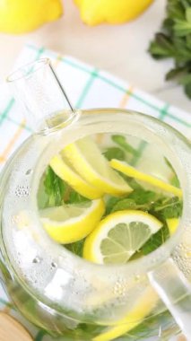 Çaydanlıkta taze nane ve limon çayı. Dikey video. Üst Manzara. Sağlıklı ev yapımı sıcak içecek..