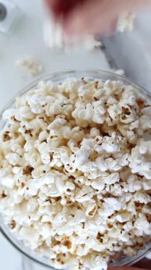 Bir kaseye yerleştirilmiş ev yapımı patlamış mısır yemek. Dikey video. Üst görünüm.