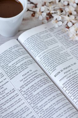 Bahar çiçeği dalı ve bir fincan kahveyle kutsal ilahiler kitabını aç. İncil 'deki adalet kavramı, Erdemli Kral, Tanrı' ya umut ve inanç..