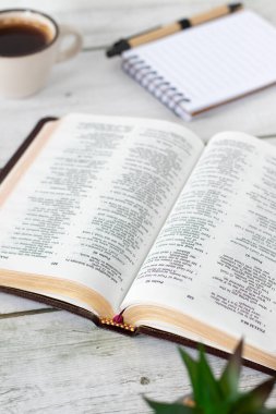 Kutsal İncil 'i aç, içinde kahve fincanı ve defter olsun. Hristiyanlık kitabı, İncil konsepti.