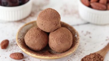 Ev yapımı çikolatalı trüf mantarının üstüne kakao tozu serpiyorum. Yakın plan. Çiğ enerji abur cuburu veya tatlı tatlı süslemesi.