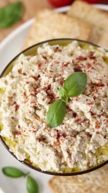 El, ev yapımı vegan ricotta peynirine kraker batırıyor. Dikey video. Yakın plan. Sağlıklı çerez konsepti.