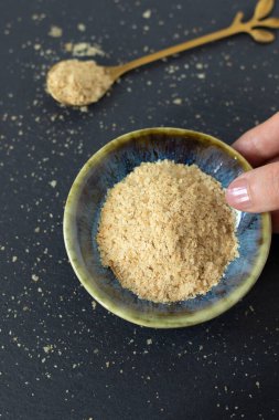 El, içinde besin maya taneleri olan bir kase tutuyor. Üst Manzara. Sağlıklı vejetaryen peyniri.