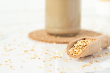 Tahini kavanozlu tahta kaşıkta susam tohumu. Yakın plan..