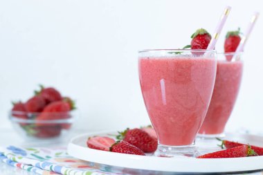 Beyaz arkaplanlı, cam kaplı çilekli kahvaltı içeceği. Yakın plan. Boşluğu kopyala.