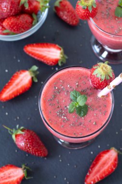 Chia tohumlu çilekli smoothie ve koyu arkaplanda taze nane. Üst görünüm.