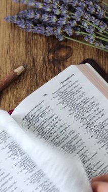 Tahta masadaki açık kutsal kitaptan ders çalışmak ve okumak. Dikey video.