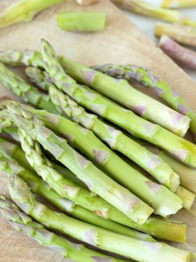 Tahta kesme tahtasında taze kuşkonmaz. Yakın plan. Seçici odak.