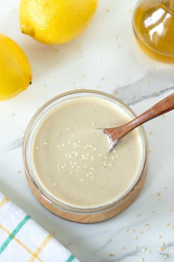 Tahini limon beyaz makarna sosu ve ahşap kaşık. Üst görünüm.