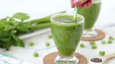 El taze yeşil smoothie ile kereviz ve chia tohumlarını karıştırıyor..