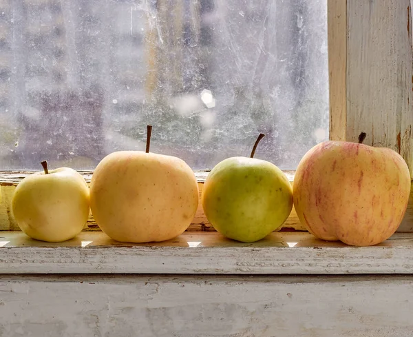 Yellows and green apple on the windowsill.