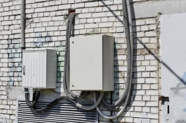 Electric distribution box on white brick wall.