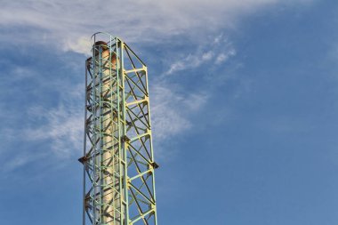 Industrial pipe with a metal frame on the background of the sky.