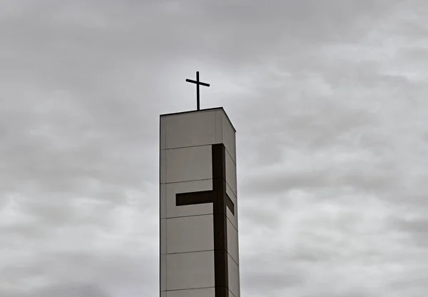 The tower with the cross on the background of the sky.