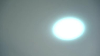 Minimalist tarzda yuvarlak tavan lambası açılıp kapanıyor. Beyaz tavan ve beyaz lamba