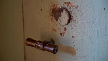 Eski, paslı bir metal kapıyı çalan bir insan eli. Yıpranmış Yüzeyin Yakın Çekim Detayları ve Çarpma Hareketi. Kullanılmış ve paslı metal kasa kapısını çalmak üzere olan bir elin yakın plan görüntüsü. 