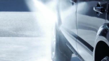 Siyah araba tekerleği kenarını sabunlu su spreyiyle durulamak, oto yıkama makinesi yıkamak.