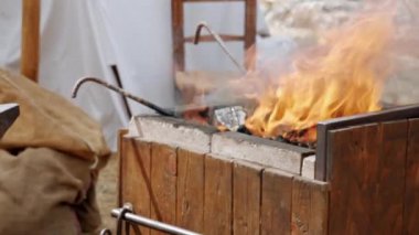 Ortaçağ canlandırması. Yakın plan demirci fuar sırasında bir ortaçağ tarlasında demir ocağında çalışıyor.