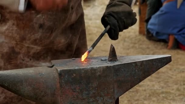 中世の歴史的再現 フェア中に中世のフィールド内のアンビルに鉄を打つことによって 金属を鍛造するクローズアップショット鍛冶 — ストック動画