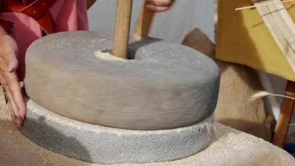 中世纪历史重演 用手使用一个大的正宗磨石 中世纪器皿将谷物和谷类磨成面粉 — 图库视频影像