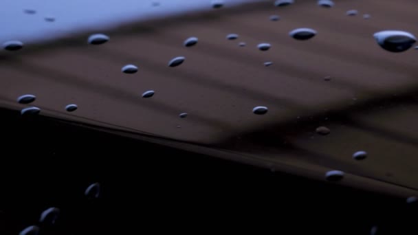 光沢のある黒い金属の表面に水が落ちる — ストック動画