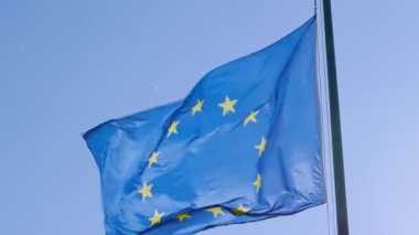Bayrak direğindeki Avrupa bayrağı mavi gökyüzü arkaplanlı rüzgarda