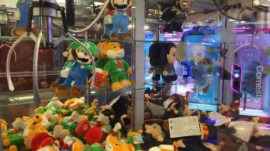 Cagliari, Sardinya, İtalya: AUG 01 2023: Oyun salonu çocukları popüler karakterlerin kuklalarını kazanmak için pençe vinçle oyun odası