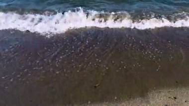 Deniz dalgaları ve deniz köpüğüyle kıyı şeridinin ön görüntüsü