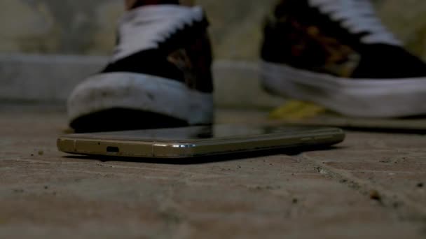 把生气的年轻女人关在鞋底下的智能手机上摔坏了 — 图库视频影像
