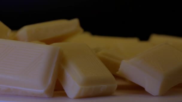 Fehér Csokoládé Rúd Darabjainak Forgatása Amelyet Egy Kéz Ujjai Emelnek — Stock videók