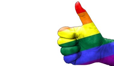 LGBT hakları bayrağıyla onaylanmış bir el. Beyaz arkaplan kopyalama alanına sahip izole resim