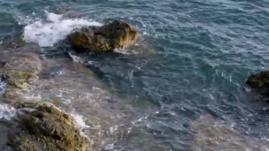 Akdeniz dalgaları bir yaz günü kayalıklara çarpıyor.