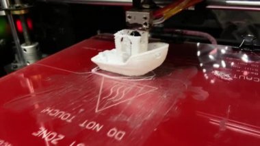 3D yazıcı Pla plastik filament içinde küçük beyaz bir test botu yaratıyor. Oyuncak, nesne ve aksesuar üretimi üç boyutlu filament yazdırma