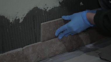 Ev işleri, evin duvarını karolarla dekore eden eldivenli eller, el işi, ev dekorasyonları.