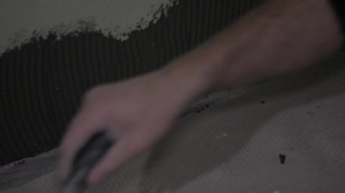 Bir seramik işçisinin tutkal ya da duvar çimento üzerine fayanslar yerleştirdiği yakın plan bir çekim. Ev dekorasyonu için profesyonel DIY dekorasyonları