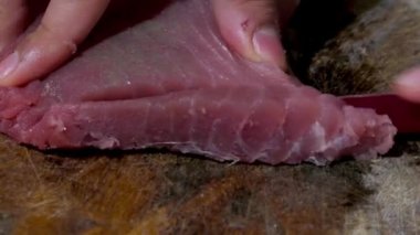 Pişirmek ya da çiğ yemek için çiğ ton balığını filetoya dönüştürmek. Bıçak keserken yakın çekim