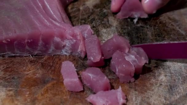 クローズアップショットナイフ 生のブルーフィンマグロのスライスをキューブに切って 生を調理または食べます 日本料理 タンパク質ダイエット — ストック動画