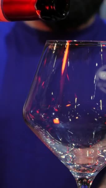 レストランでガラスに注がれた赤ワインのクローズアップショット垂直ビデオボトル 赤ワイン ライフスタイル アルコール — ストック動画