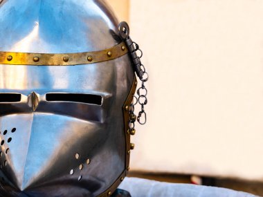 Ortaçağ metal kaskının bir tarafından yakın plan çekimleri ve arka planda beyaz bir afiş. Boş kopya alanı olan ortaçağ savaş ekipmanları