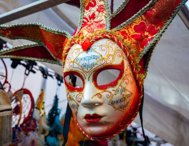 Venedik Karnavalı 'ndan satılık kırmızı, beyaz ve altın bir maske. Soytarı figürünü anımsatıyor. İtalyan sanatı ve kültürü, şenlikler ve gelenekler