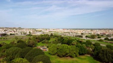 4k drone, çocuklar için oyun parkı ve büyük yeşil çimenler olan bir şehir parkının panoramik görüntüsünü kaydediyor. İnsansız hava aracı videosu şehri ve doğayı parkediyor