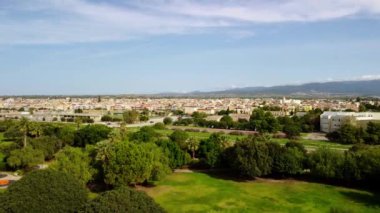 Şehir parkının panoramik görüntüsü için 4K drone görüntüsü. Küçük bir nehir ve büyük yeşil çimenler ilerliyor. İnsansız hava aracı videosu şehri ve doğayı parkediyor