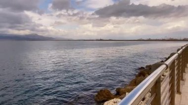 Metal bir korkuluktan gelen panoramik deniz ufku kıyı yürüyüşü, bulutlu gökyüzü. Hava ve doğa, okyanus.